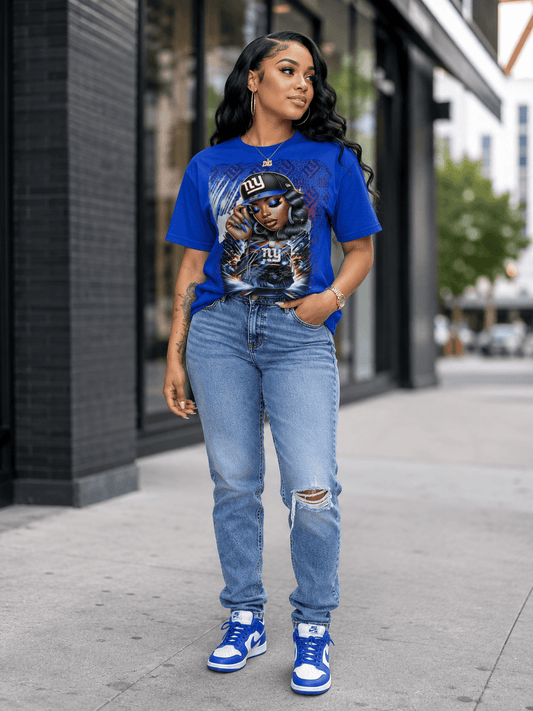 Woman wearing a blue graphic t-shirt and jeans standing on a sidewalk.
